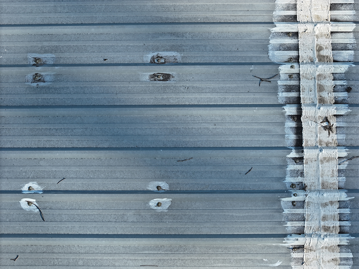 Rust-ringed metal roof fasteners spot-treated with sealant